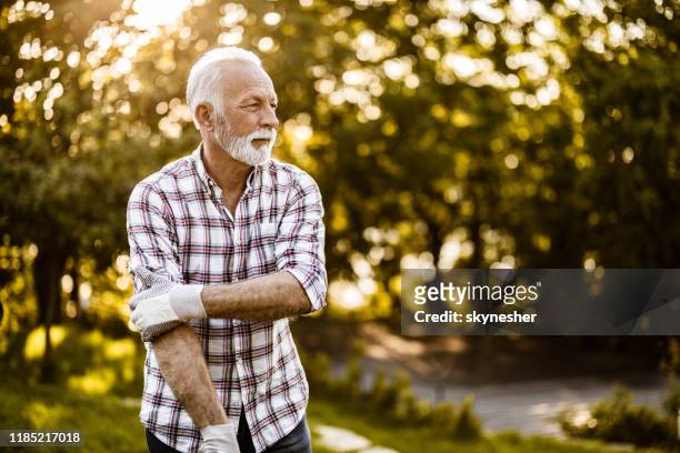 senior man klaar voor tuinieren in de natuur. - male volunteer stockfoto's en -beelden