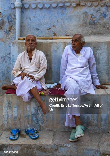 Indian men sit in front of an old blue house of a brahmin, Rajasthan, Bundi, India on July 16, 2019 in Bundi, India.