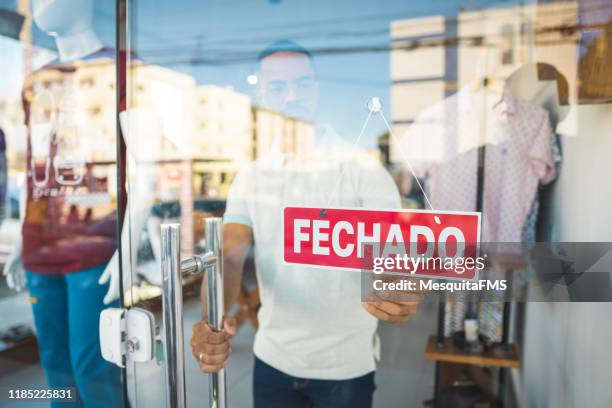 vendedor cerrando la tienda de ropa - closed fotografías e imágenes de stock