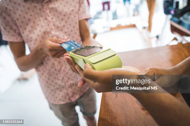 close up of customer inserting credit card - inserting stock pictures, royalty-free photos & images