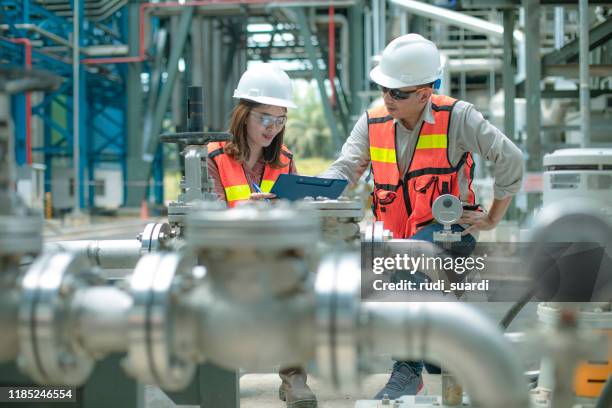 stromingenieur und sein vorgesetzter in der industrie - petrochemische fabrik stock-fotos und bilder