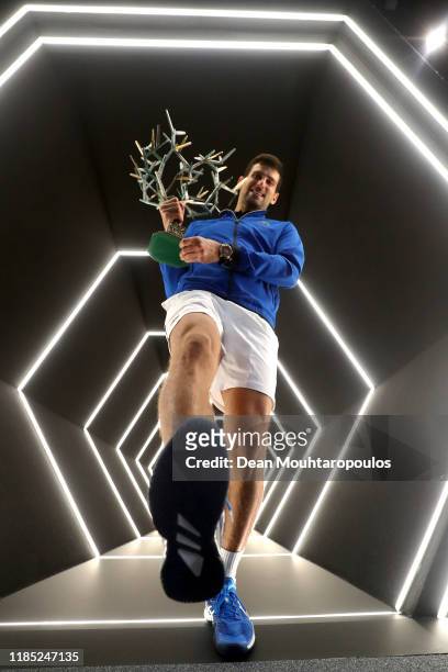 Novak Djokovic of Serbia celebrates with the trophy in the player walk in tunnel after victory in the Men's Singles Final match against Denis...