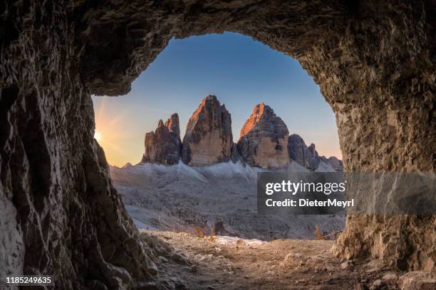 atemberaubende aussicht auf tre cime di lavaredo von der höhle bei sonnenaufgang - zinnen stock-fotos und bilder