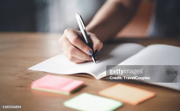 business woman working at office with documents on his desk, business woman holding pens and papers making notes in documents on the table, hands of financial manager taking notes - message stock-fotos und bilder
