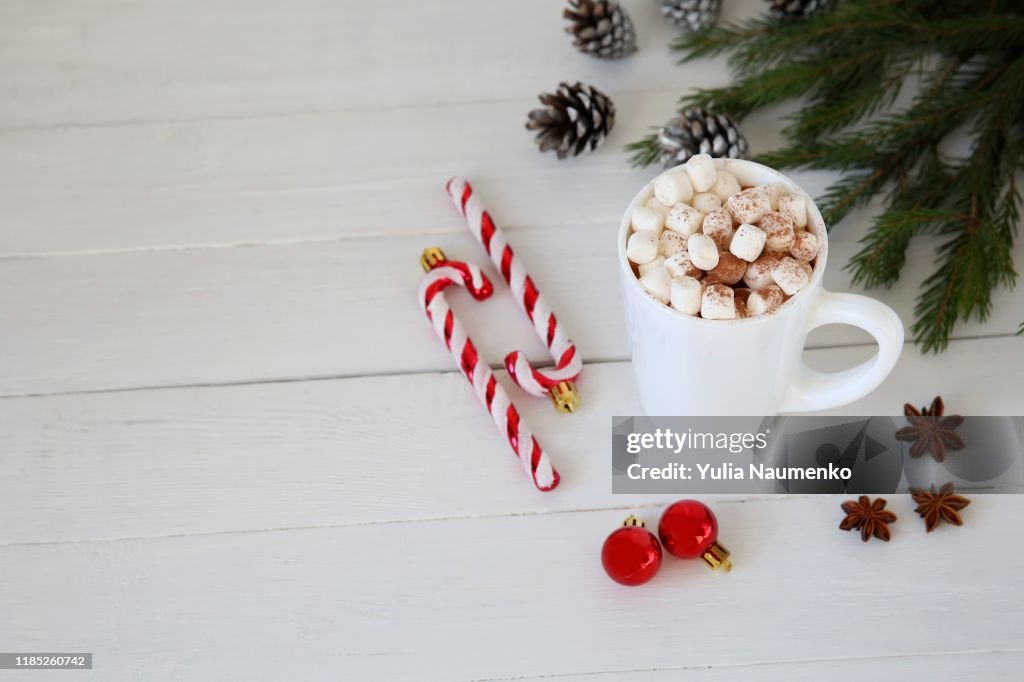 Christmas Hot chocolate with marshmallows, Christmas toy peppermint candy cane at mug, copy space.