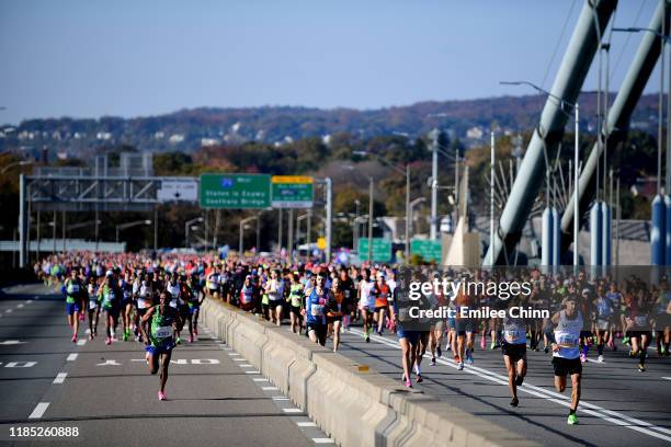 Participants of the TCS New York City Marathon run over the Verrazzano Bridge at the start of the race on November 03, 2019 in the Staten Island...