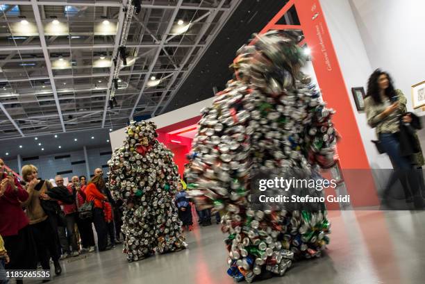 Visitor looks artistic performance LES HOMME CANETTE of Eddy Ekete Mombesa during the Flashback Contemporary Art Fair on November 03, 2019 in Turin,...