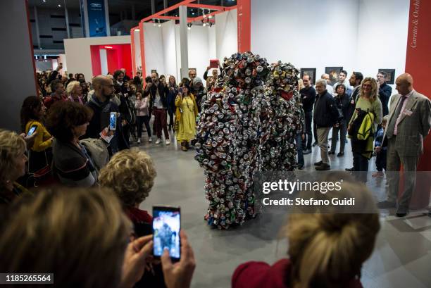Visitor looks artistic performance LES HOMME CANETTE of Eddy Ekete Mombesa during the Flashback Contemporary Art Fair on November 03, 2019 in Turin,...