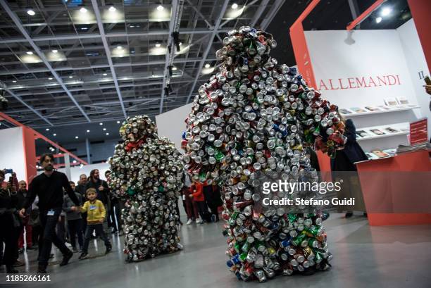 Visitors watch artistic performance LES HOMME CANETTE of Eddy Ekete Mombesa during the Flashback Contemporary Art Fair on November 03, 2019 in Turin,...