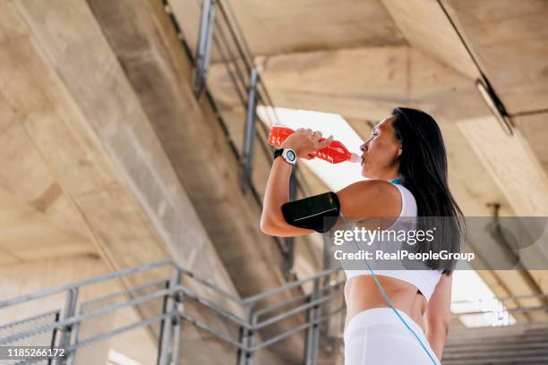 beautiful asian girl drinking water from a bottle after jogging. - energy drink stock pictures, royalty-free photos & images