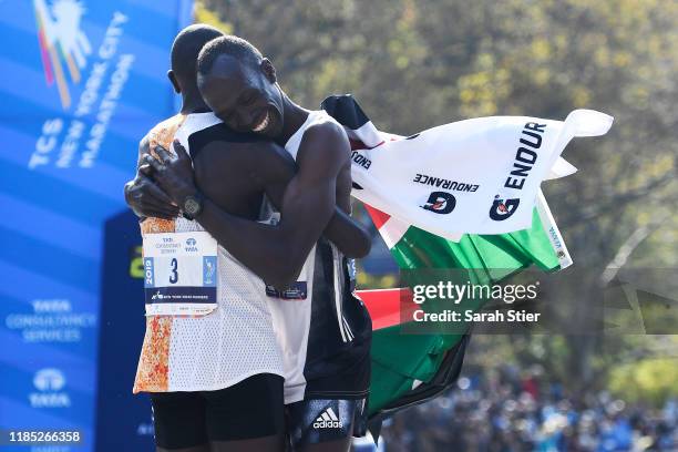 Geoffrey Kamworor, of Kenya, left, embraces Albert Korir of Kenya after the two runners take first and second place respectively in the Men's...