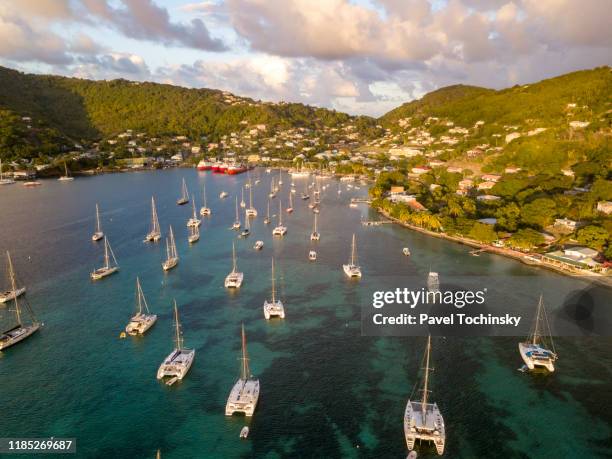 yachts and sail boats moored in the port elizabeth harbor bequia at sunset, saint vincent and the grenadines, 2019 - bequia stock-fotos und bilder