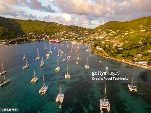 yachts and sail boats moored in the port elizabeth harbor bequia at sunset, saint vincent and the grenadines, 2019 - bequia stock pictures, royalty-free photos & images