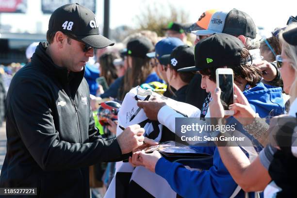 Jimmie Johnson, driver of the Ally Chevrolet, signs autographs for fans prior to the Monster Energy NASCAR Cup Series AAA Texas 500 at Texas Motor...