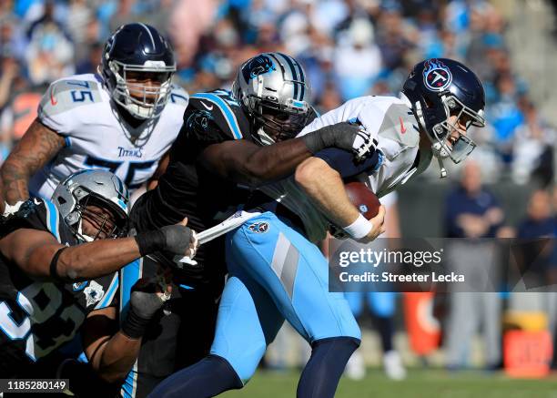 Teammates Kyle Love and Gerald McCoy of the Carolina Panthers try to stop Ryan Tannehill of the Tennessee Titans during their game at Bank of America...