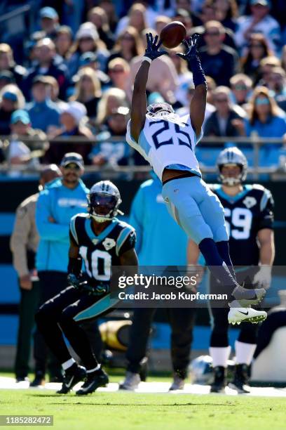 Adoree' Jackson of the Tennessee Titans tries to make an interception but the ball goes through his hands and is caught by Curtis Samuel of the...