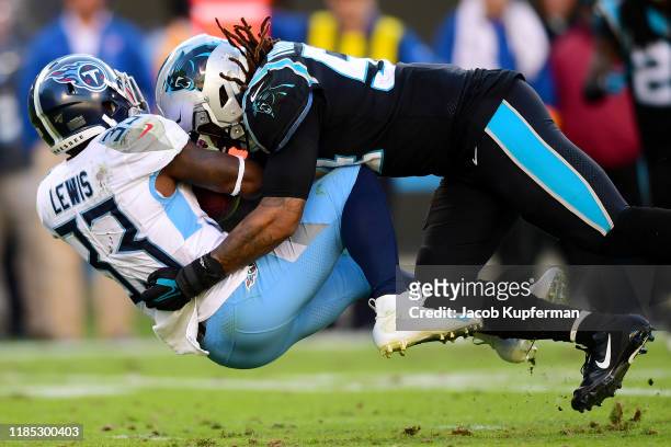 Dion Lewis of the Tennessee Titans is tackled by Shaq Thompson of the Carolina Panthers during their game at Bank of America Stadium on November 03,...