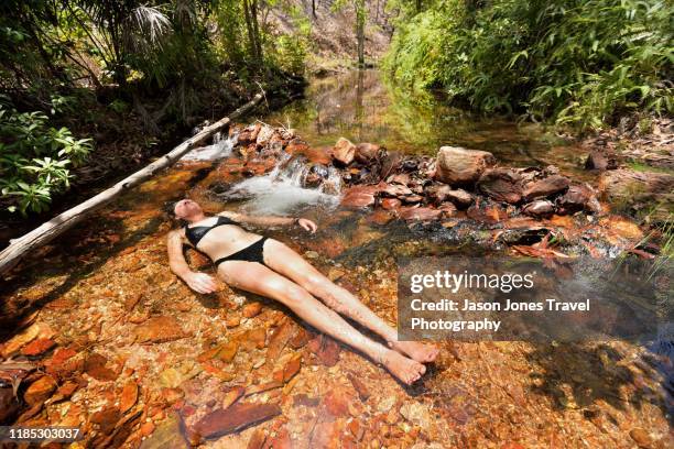 woman relaxes in a stream - river bottom park stock pictures, royalty-free photos & images