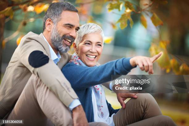 late mid adult couple having fun in a park. - november 2 2017 stock pictures, royalty-free photos & images