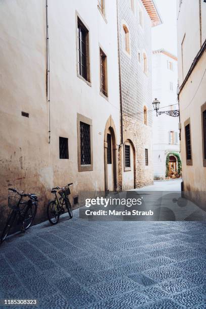 bicycle leaning on wall in narrow street of florence, italy - vicolo foto e immagini stock