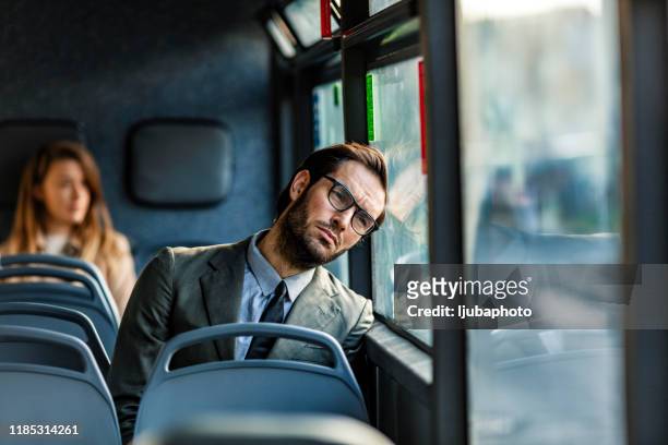 müde geschäftsmann im bus - boring man stock-fotos und bilder