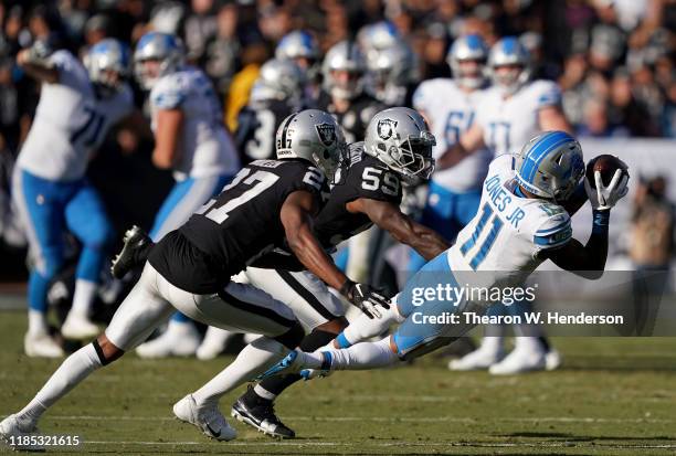 Marvin Jones of the Detroit Lions makes a diving catch over Tahir Whitehead and Trayvon Mullen of the Oakland Raiders during the third quarter of an...