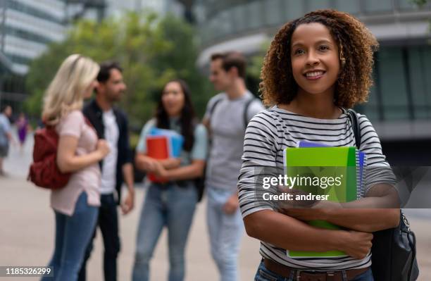 thoughtful student smiling outdoors - international students stock pictures, royalty-free photos & images