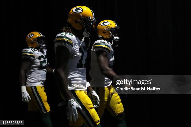 Jaire Alexander, Davante Adams and Adrian Amos of the Green Bay Packers walk onto the field prior to a game against the Los Angeles Chargers at...