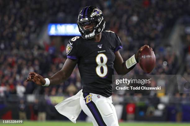 Quarterback Lamar Jackson of the Baltimore Ravens scores a first quarter touchdown against the New England Patriots at M&T Bank Stadium on November...