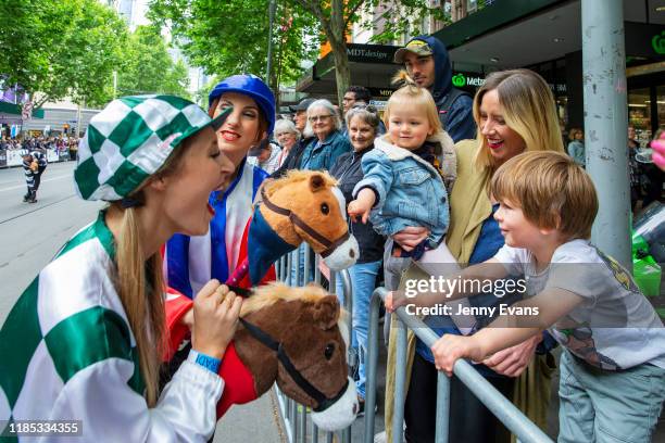 Children react to toy horses held by performers during the 2019 Melbourne Cup Parade on November 04, 2019 in Melbourne, Australia.