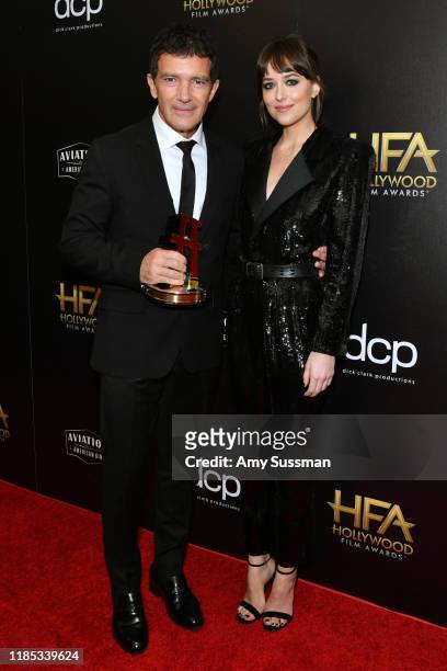 Antonio Banderas, winner of the Hollywood Actor Award, and Dakota Johnson pose in the press room during the 23rd Annual Hollywood Film Awards at The...