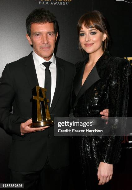 Antonio Banderas, winner of the Hollywood Actor Award, and Dakota Johnson pose in the press room during the 23rd Annual Hollywood Film Awards at The...