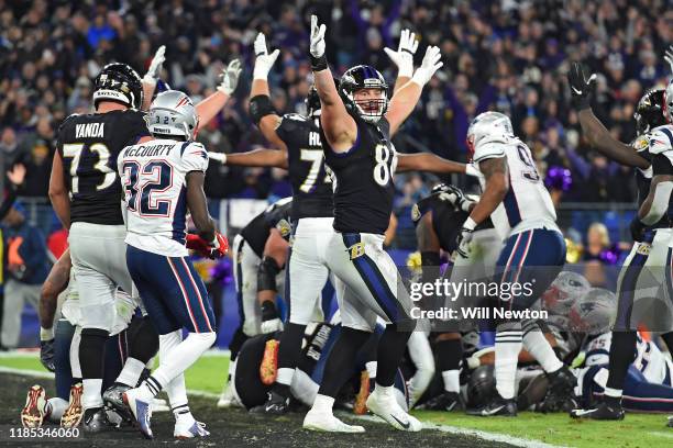 Teammates celebrate a touchdown by quarterback Lamar Jackson of the Baltimore Ravens against the New England Patriots during the fourth quarter at...