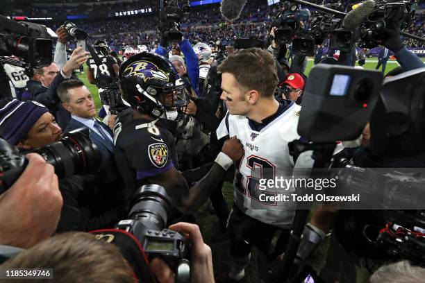 Quarterback Lamar Jackson of the Baltimore Ravens and quarterback Tom Brady of the New England Patriots talk after the Ravens defeated the Patriots...