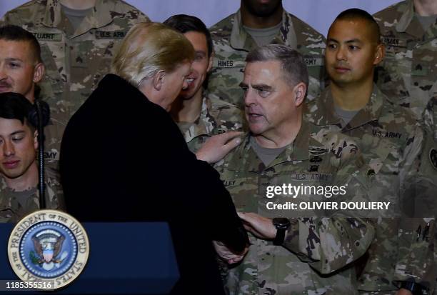 President Donald Trump shakes hands with Joint Chiefs Chairman General Mark Milley after addressing the troops at Bagram Air Field during a surprise...