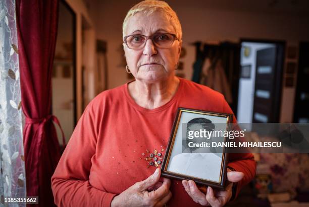 Elena Bancila poses with a portrait of her son, Bogdan Stan, at her home in the village of Joita, next to Bucharest on November 26, 2019. - On the...
