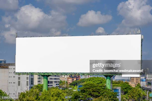 large blank billboard on road with city view background - sneering stock pictures, royalty-free photos & images