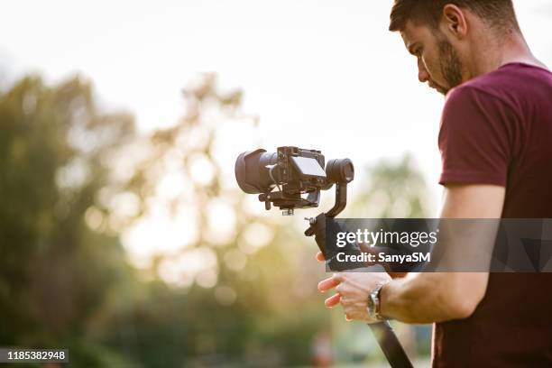 junger mann und seine videokamera - kameramann stock-fotos und bilder