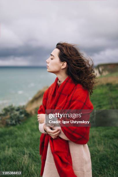 young woman wearing big wool scarf - think big stockfoto's en -beelden