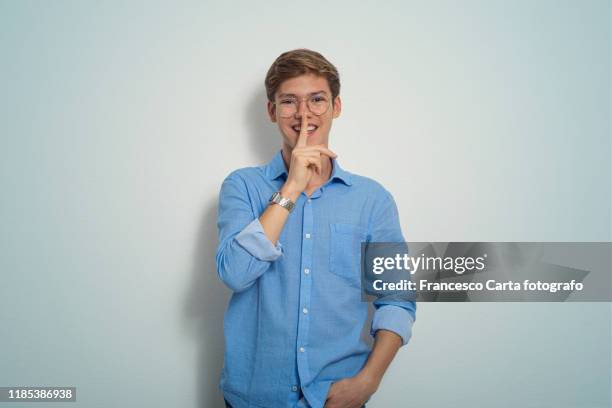 young man with finger on his mouth - man finger on lips stock pictures, royalty-free photos & images