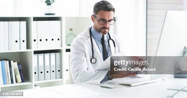 he'll keep your medical records safe - doctor paperwork stock pictures, royalty-free photos & images