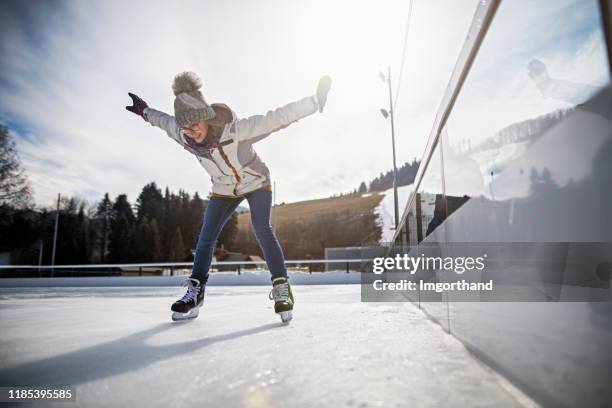 teenage girl learning to ice skate on outdoors ice rink - learning to ice skate stock pictures, royalty-free photos & images