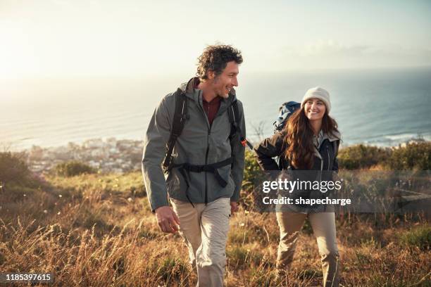 llevando su cita a la cima de la montaña - couple fotografías e imágenes de stock