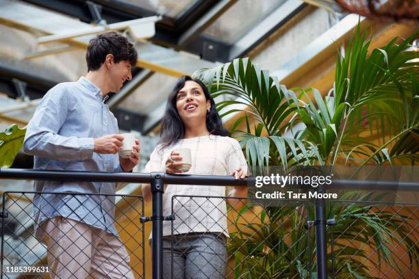 two business people looking out on balcony with coffee cup - boundary stock pictures, royalty-free photos & images