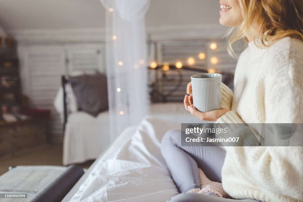 Beautiful young woman drinking coffee at home