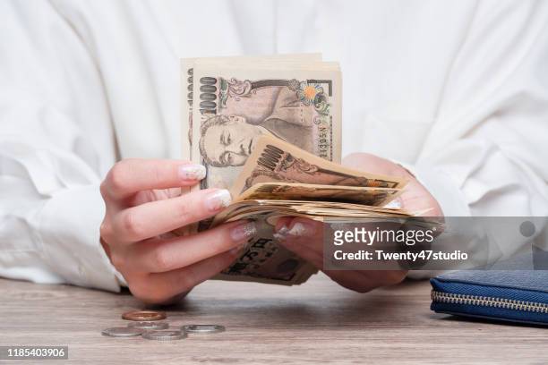 close up female hand counting japanese yen bank notes, concept of banking, saving, currency,financial - japanese yen note stockfoto's en -beelden