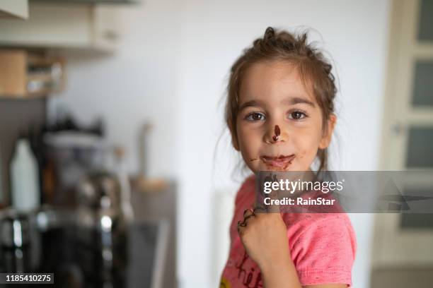 child eating chocolate with her finger - chocolate tasting stock pictures, royalty-free photos & images