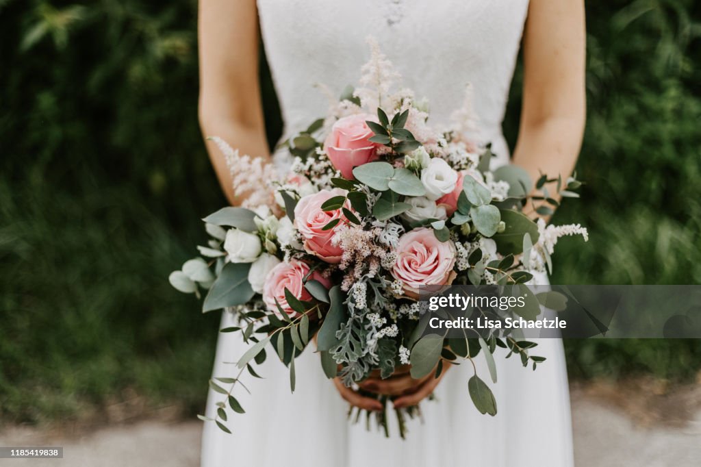 Bride holding her Bridal Bouquet with pink roses and eucalyptus