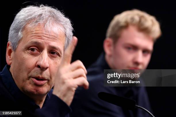 Head coach Lucien Favre gestures next to Julian Brandt during a Borussia Dortmund press conference at Signal Iduna Park on November 04, 2019 in...