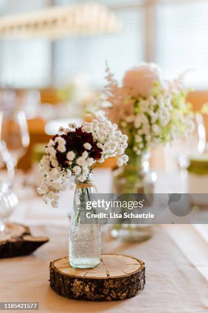 decoration at a wedding: flowers in a small vase on tree discs - centre piece stock pictures, royalty-free photos & images
